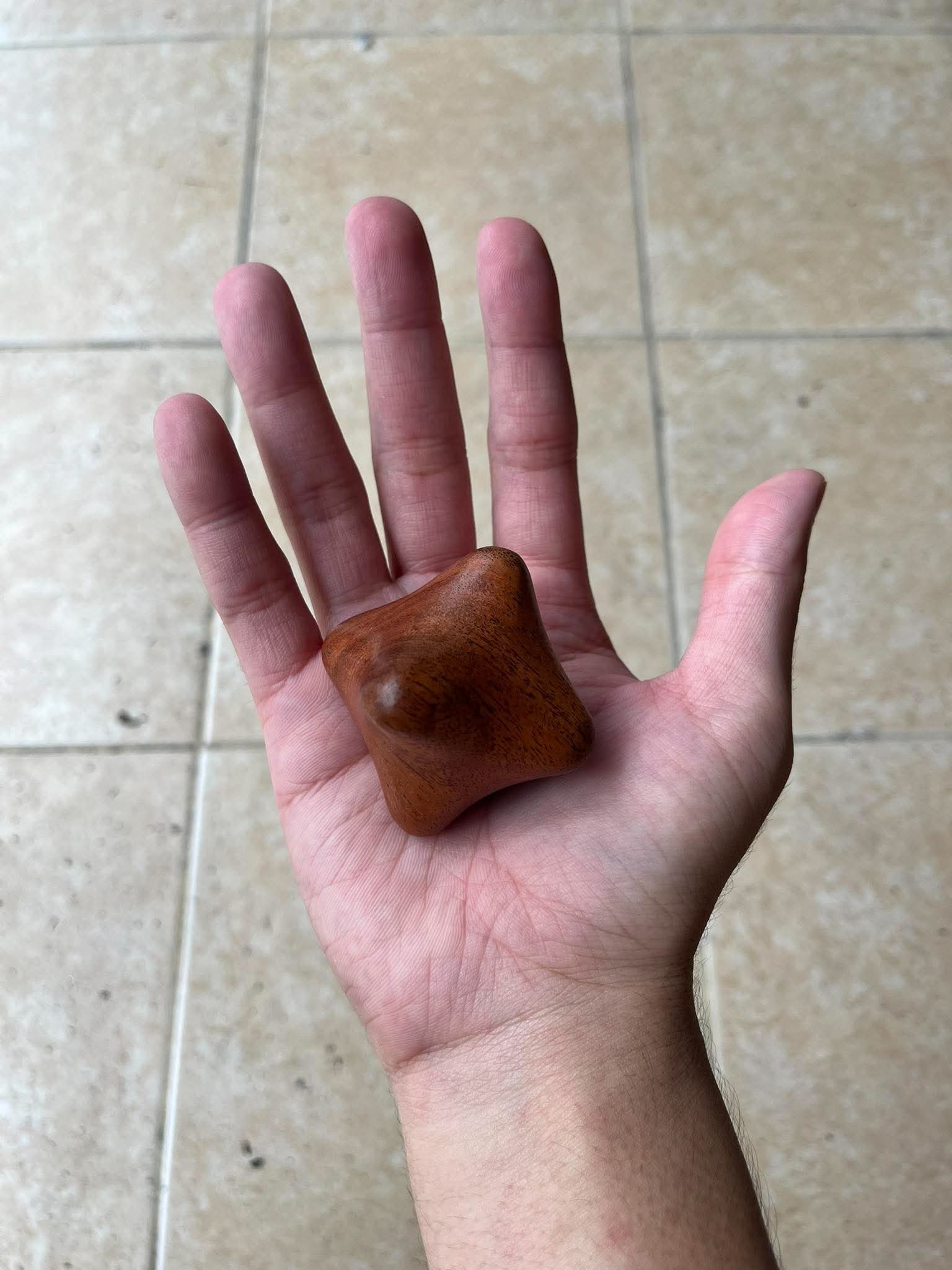 Hexagonal Thai wooden palm massager resting in palm